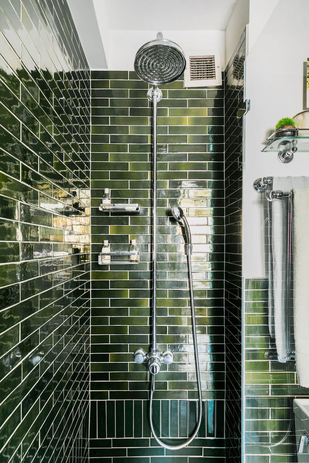 Image of vintage shower head in green tile shower
