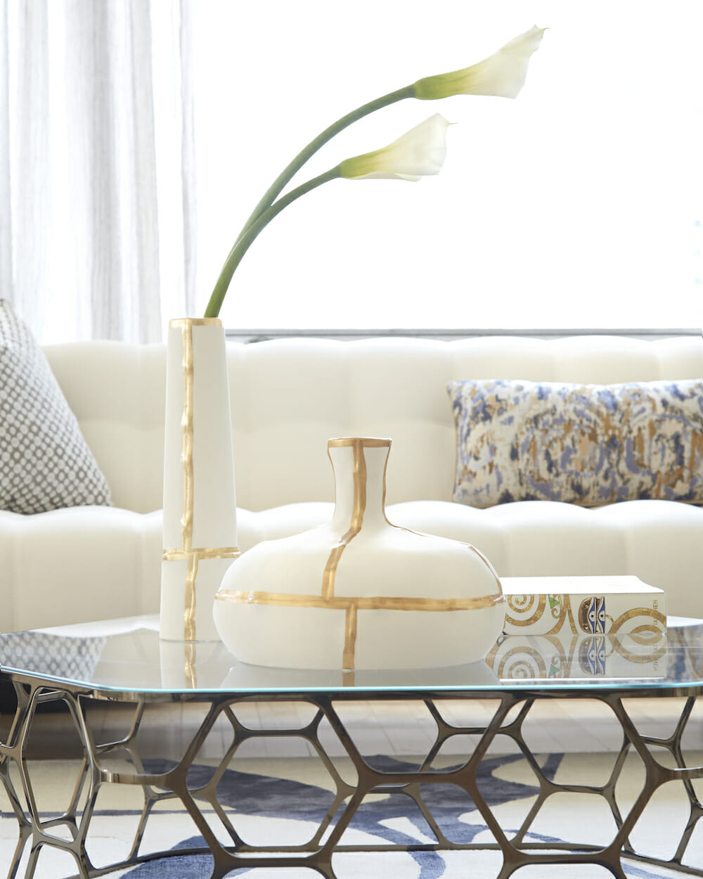 Closeup of modern living room coffee table with flower vase and modern white sofa