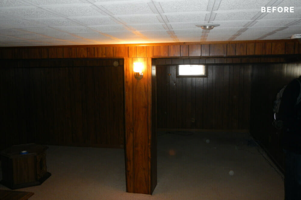 Pillar in basement and wall to wall beige carpet and shiplap walls before renovation