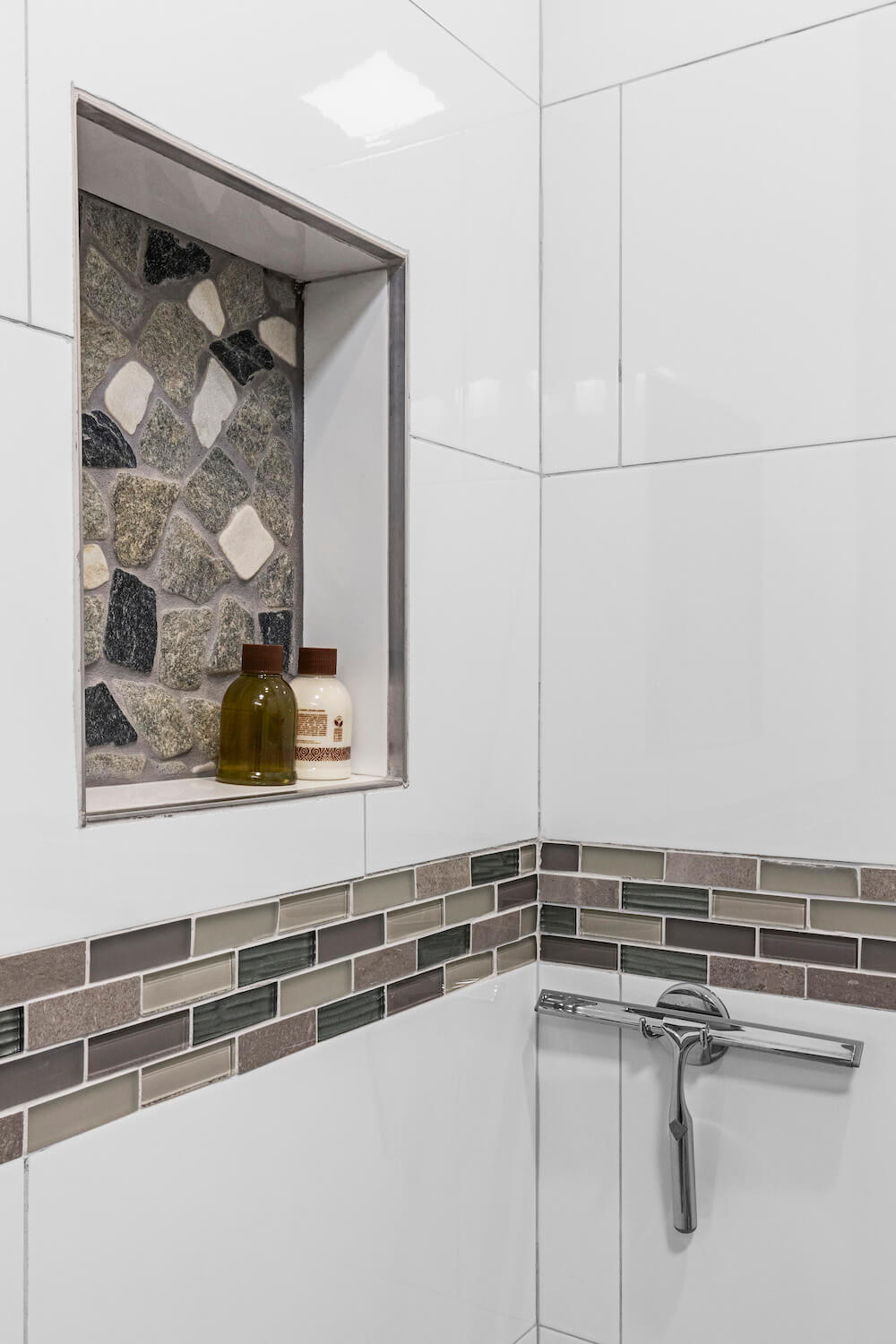 Recessed shower shelf with stone effect in a white bathroom after renovation