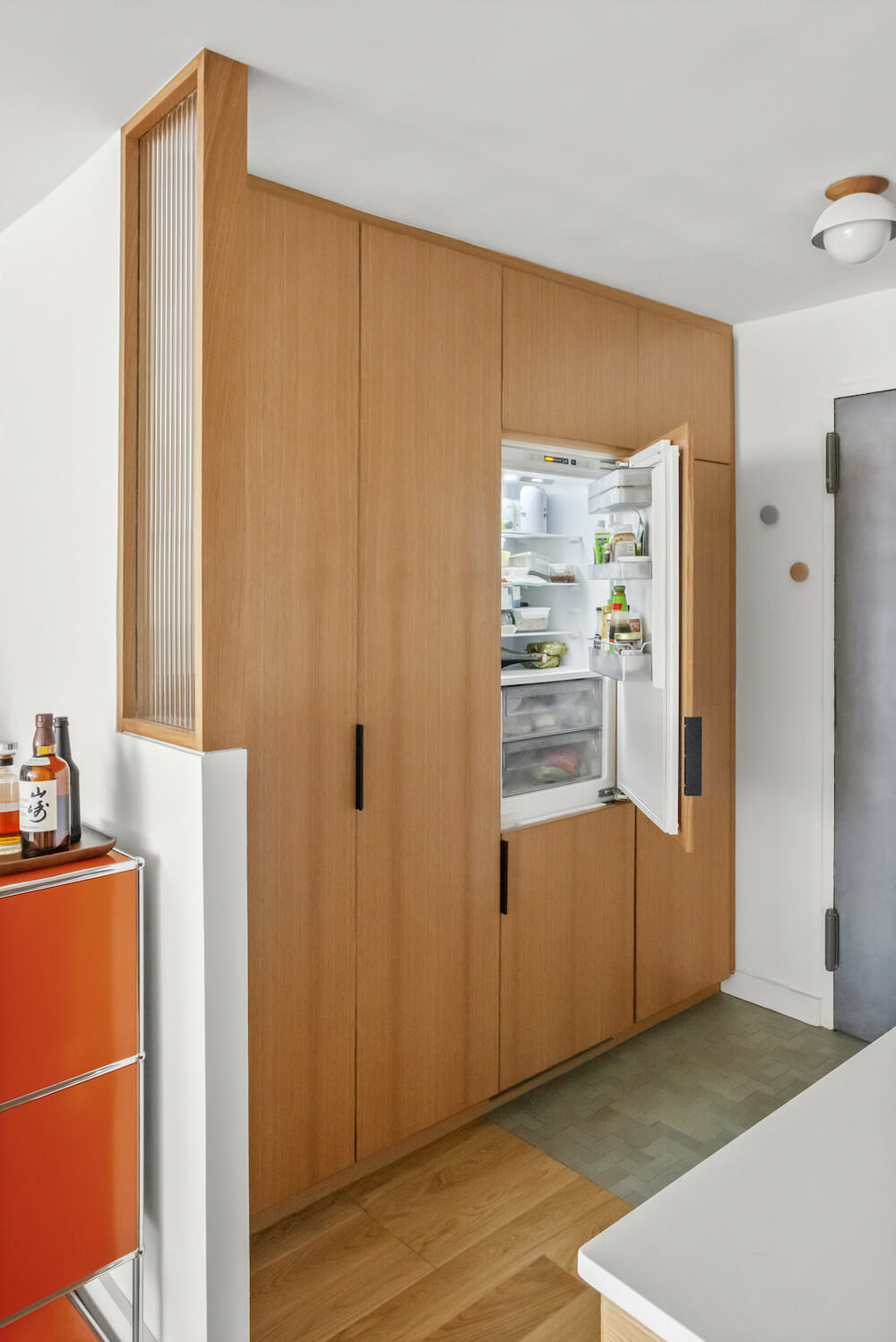 entry with tall cabinet builts in hiding refrigerator