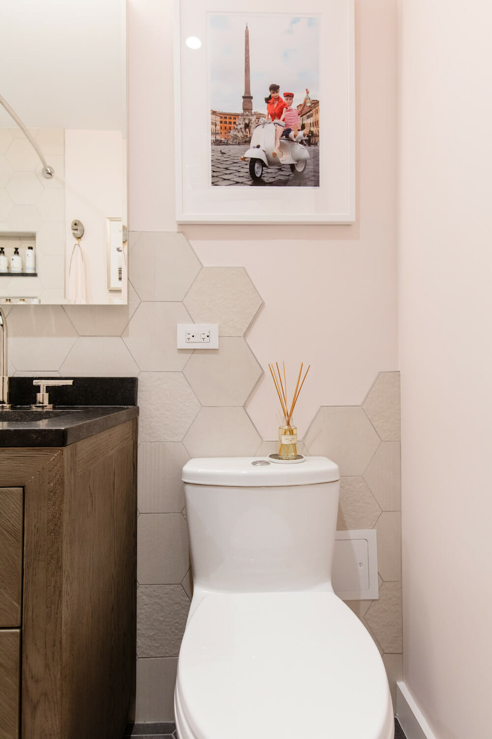 bathroom with rustic vanity and contemporary toilet and honeycomb or hexagon wall tiles and off white wall paint after renovation