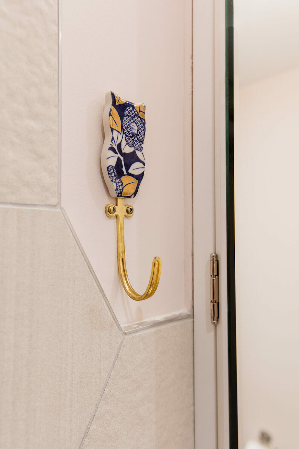 Bathrobe hook with cat design on hexagon tiled wall after renovation