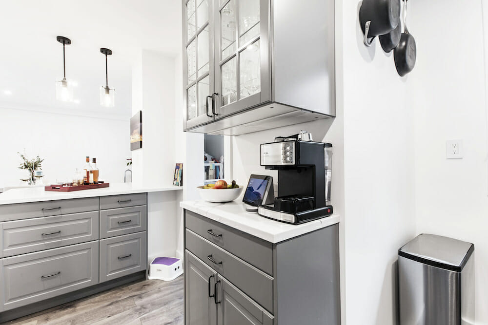 coffee or breakfast station with gray cabinets and white countertop and white walls and tile flooring that look like hardwood after renovation