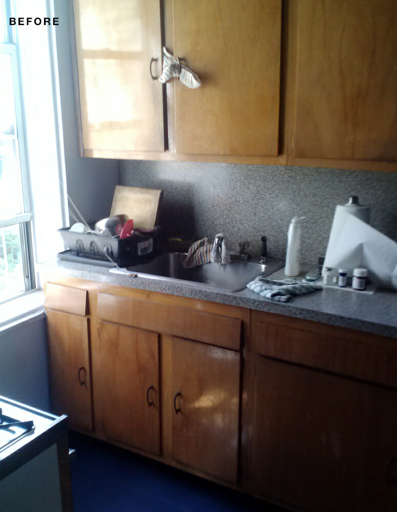 oak kitchen cabinets with gray countertop and backsplash and window before renovation