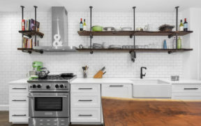 Kitchen with white subway tile walls, hardwood floors, and open shelving