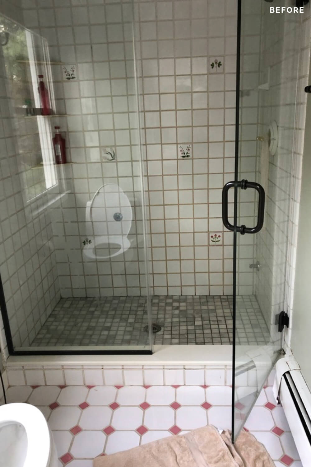 White shower area with tempered glass doors before renovation