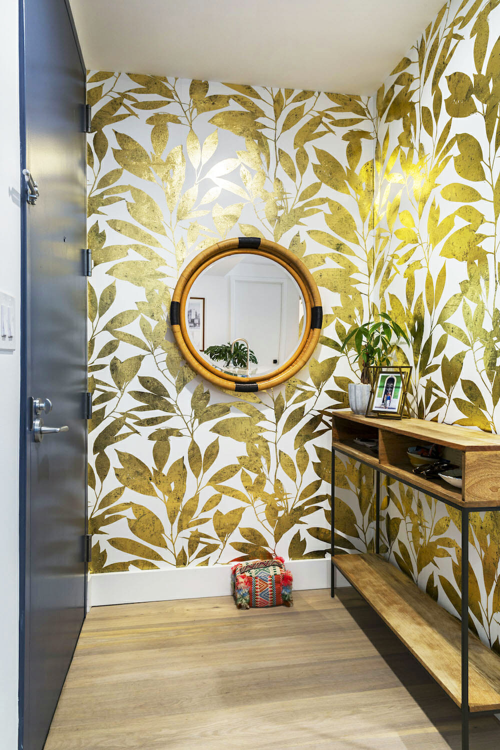 Image of an entryway with a leaf-patterned wallpaper in gold