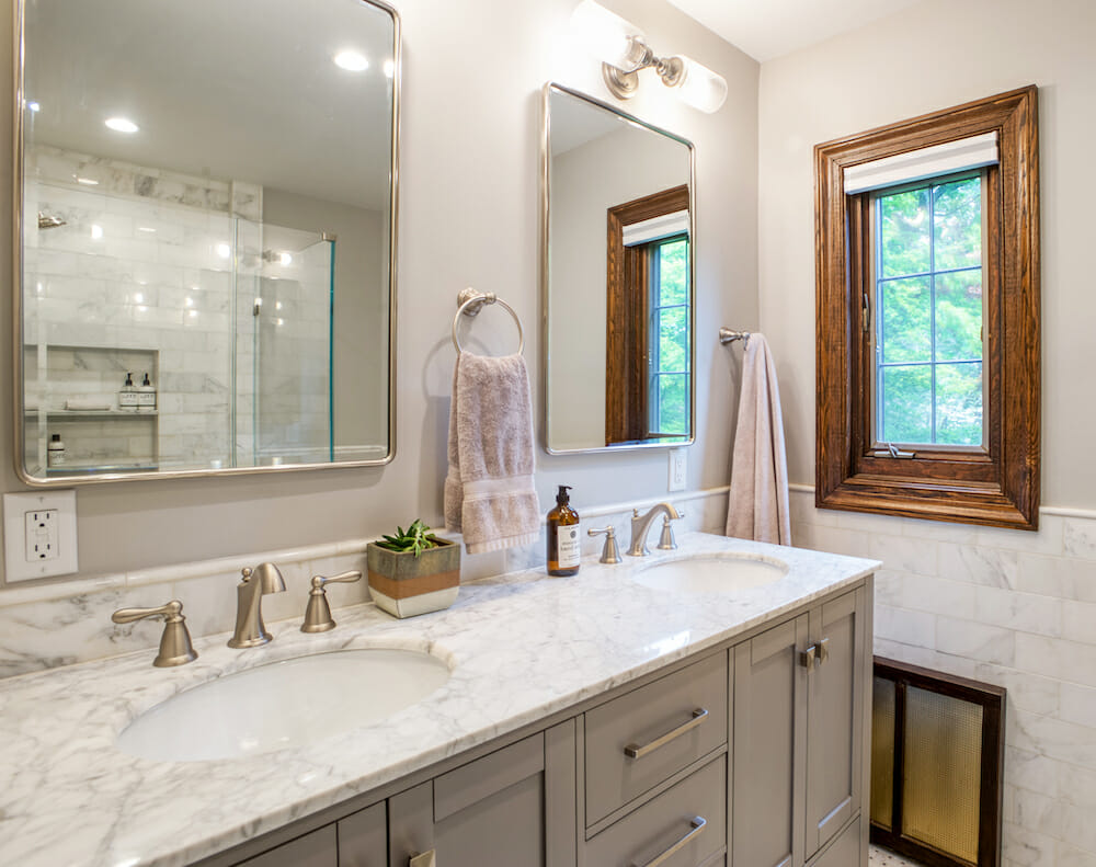 bathroom with double vanity and marble countertop and brushed nickel faucets and mirrors after renovation