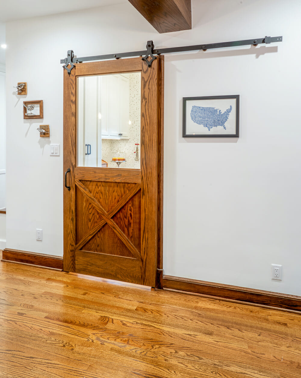 room with dark wood trim and hardwood floors and sliding barn door after renovation