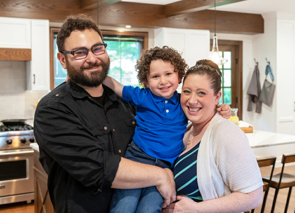 photo of sara with her husband and son in their kitchen after renovation