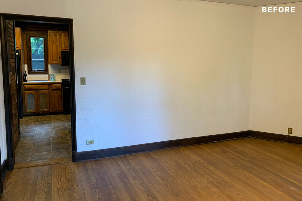 room with white walls and hardwood floors before renovation