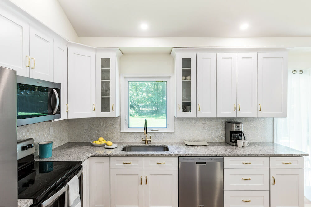 Image of kitchen after renovation with white cabinets and stone countertops