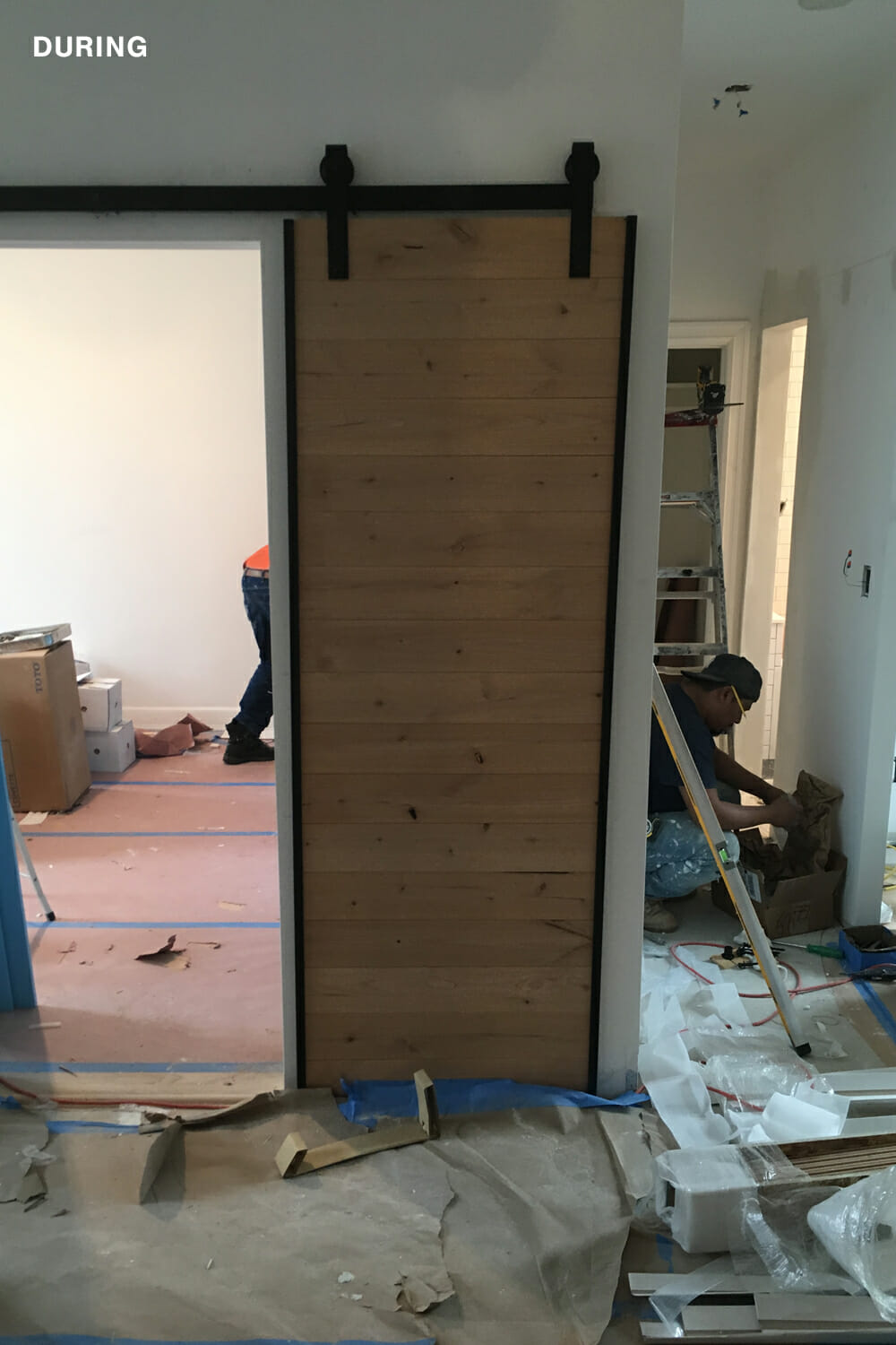 men at work in a room with barndoor during renovation 