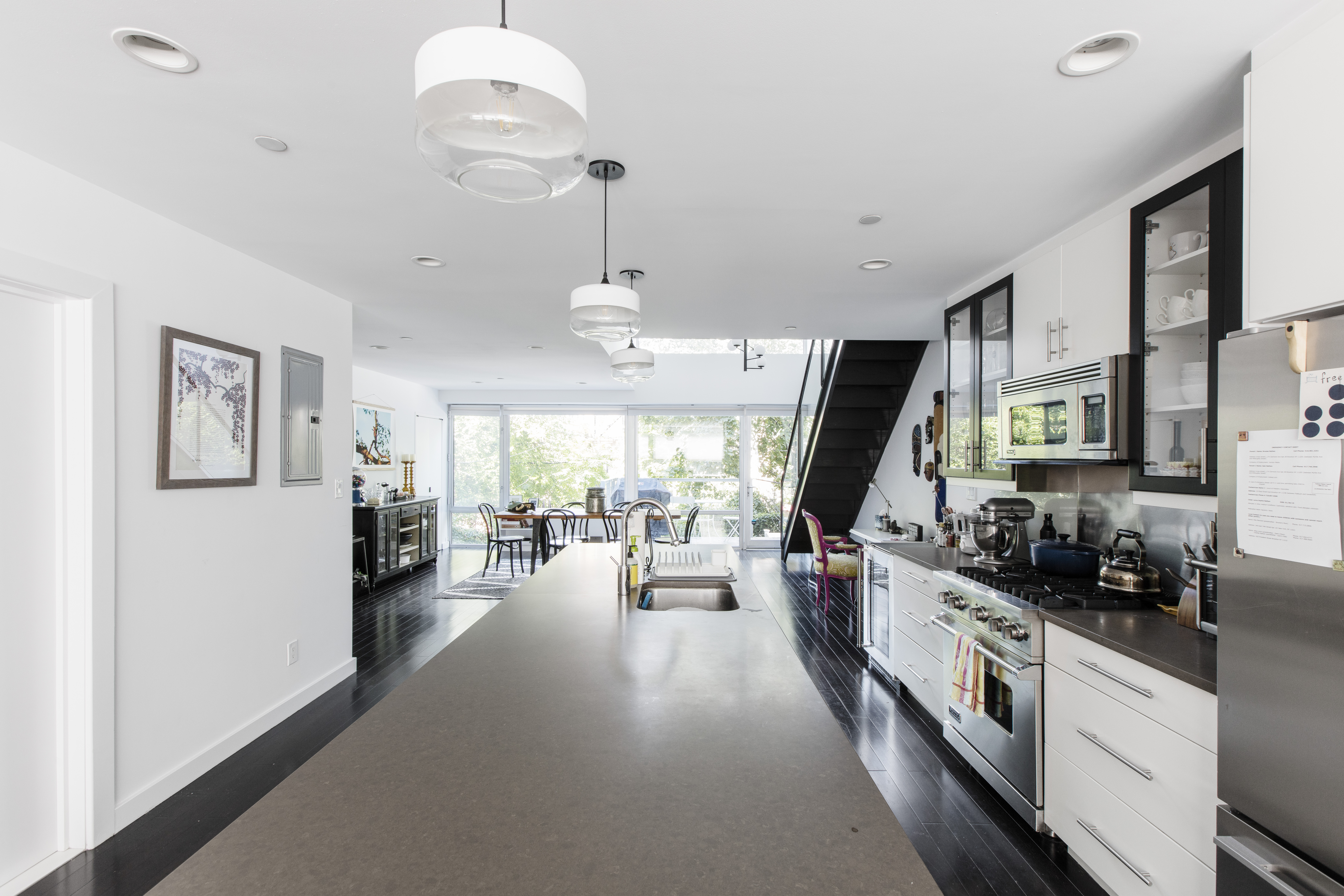 Brooke's duplex renovation featuring a refreshed kitchen with island, hanging lights, and new cabinetry