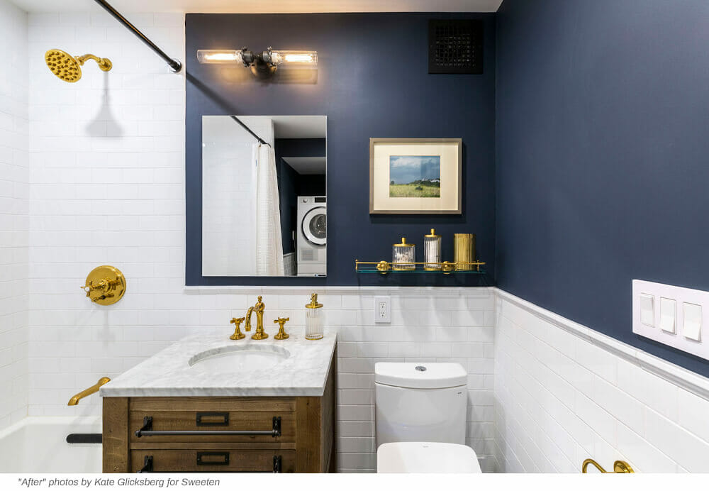White wall tiles and navy blue bathroom with white marble top washstand and wood vanity