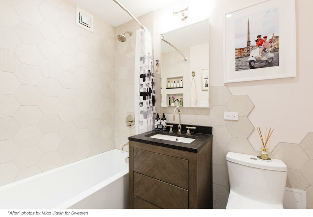 peach bathroom with hexagon backsplash and brown vanity and white bathtub after renovation