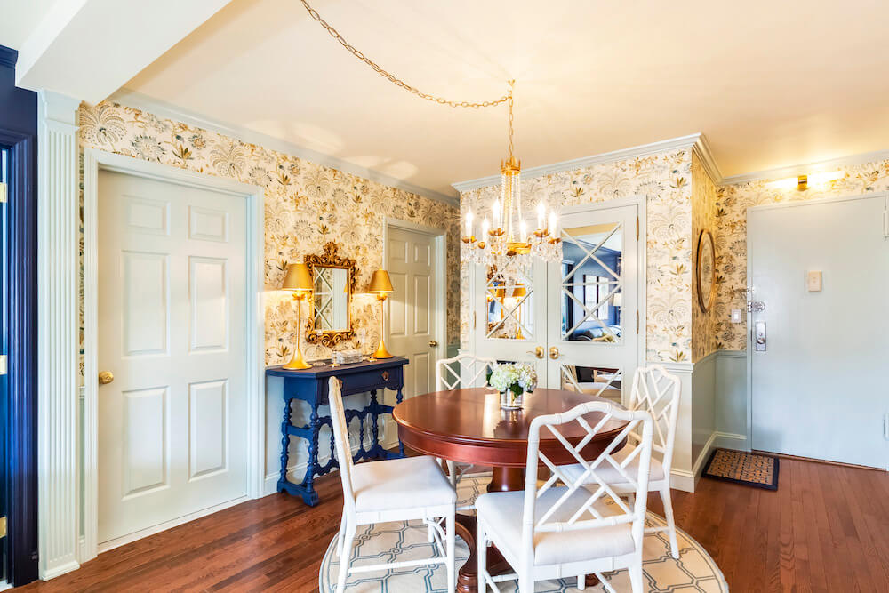 MIrror doors, decor with gold accents, and wallpaper in dining nook after renovation
