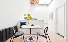Dining area with exposed beams and skylight
