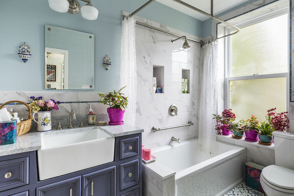Classic bathroom remodel in Brooklyn with blue vanity and stone-tile bathtub