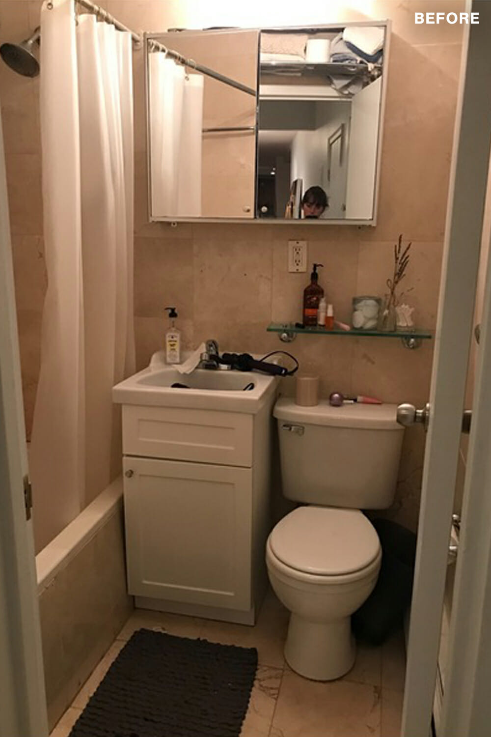 compact bathroom with single vanity and medicine cabinet and pink tiles walls and floor and bathtub before renovation