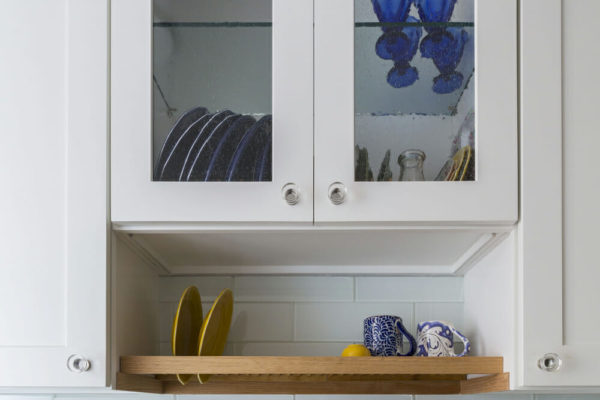 white kitchen cabinet and open shelf with white subway tiled backsplash after renovation