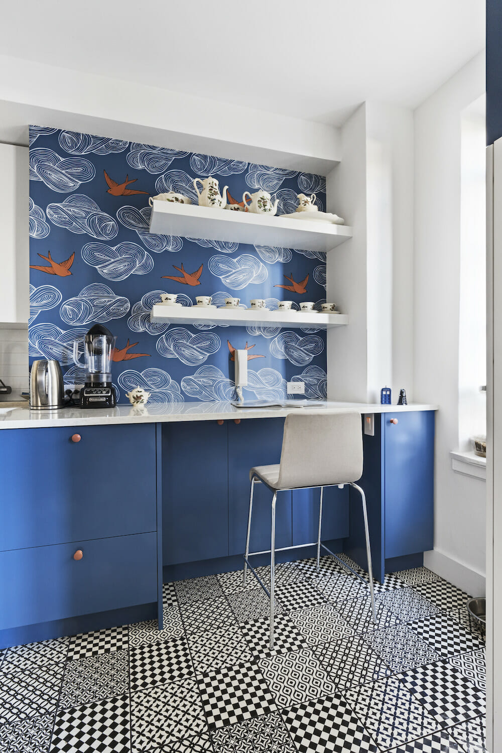 black and white patterned flooring and blue cabinets and a white desk space and blue wall paper and open white shelves after renovation