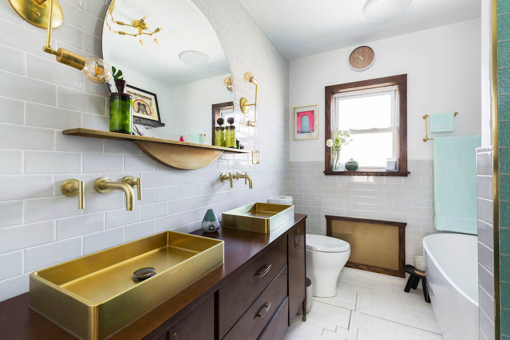 Image of a bathroom with white subway tile and gold accents