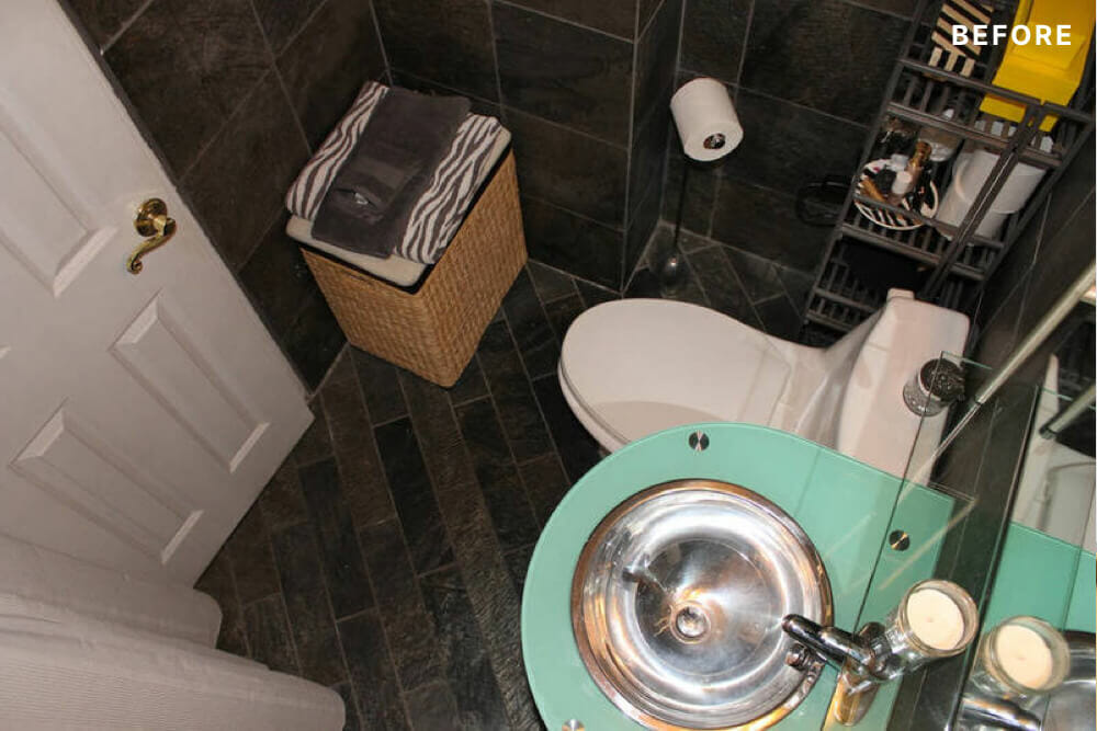small bathroom with black wall and floor tiles and floating green vessel basin sink before renovation