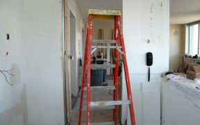 red ladder and white walls in a room under renovation