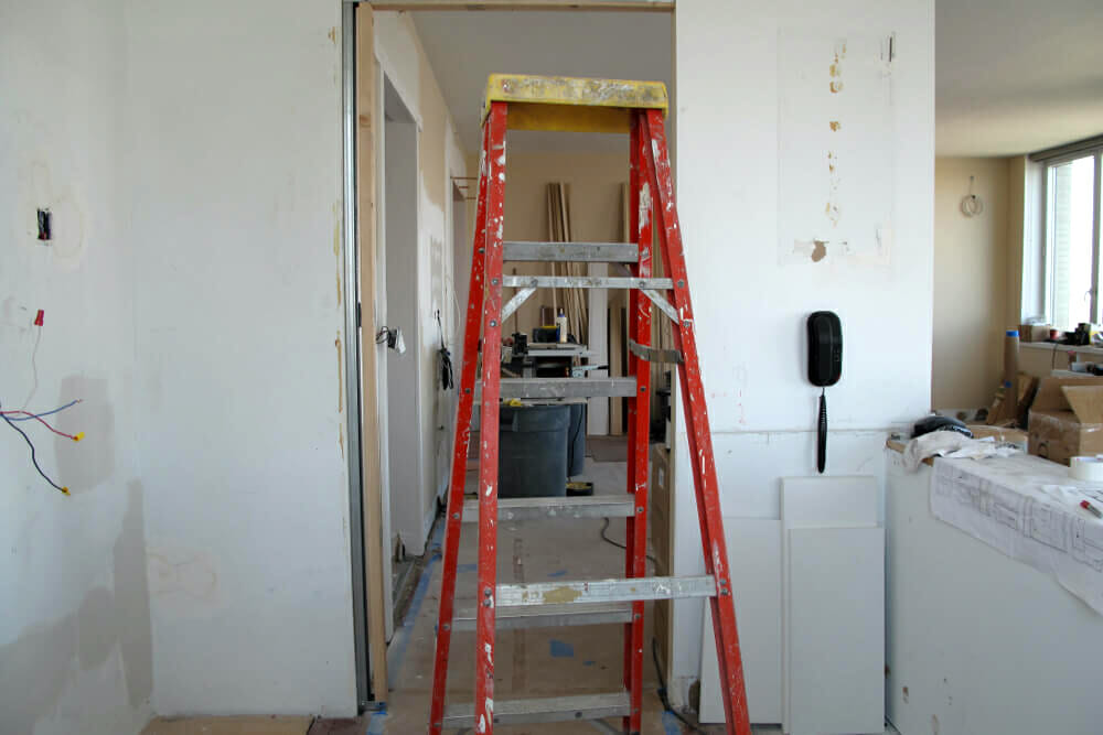 red ladder and white walls in a room under renovation