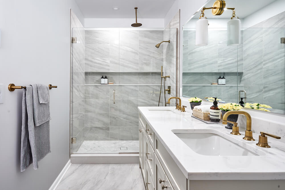 A modern Chicago bathroom with gray walls, stone tile and double vanity sink