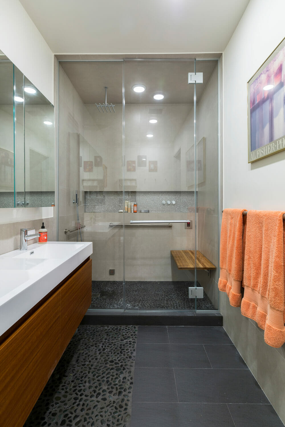 Image of bathroom with stone floor, steam shower and teak bench