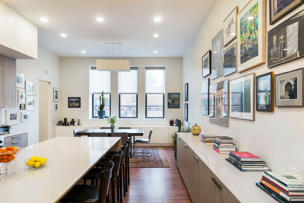 Image of kitchen countertops, wall of art and dining space