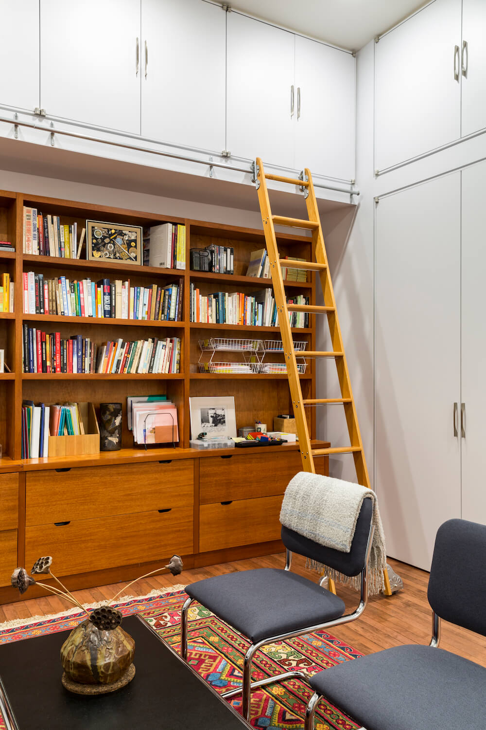 Image of a full wall bookshelf with library ladder and storage