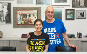 Portrait of Sweeten renovators Ilene and Neil in front of art collection