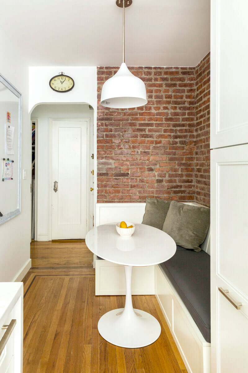 kitchen banquette with brick wall and open shelves