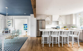Open concept kitchen with white kitchen island and barstool seating renovated by a Sweeten general contractor