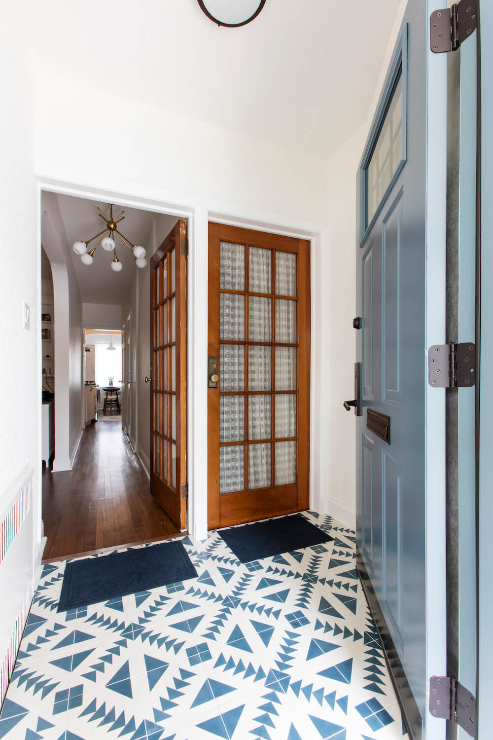 patterned tiles at entryway with two wooden doors after renovation