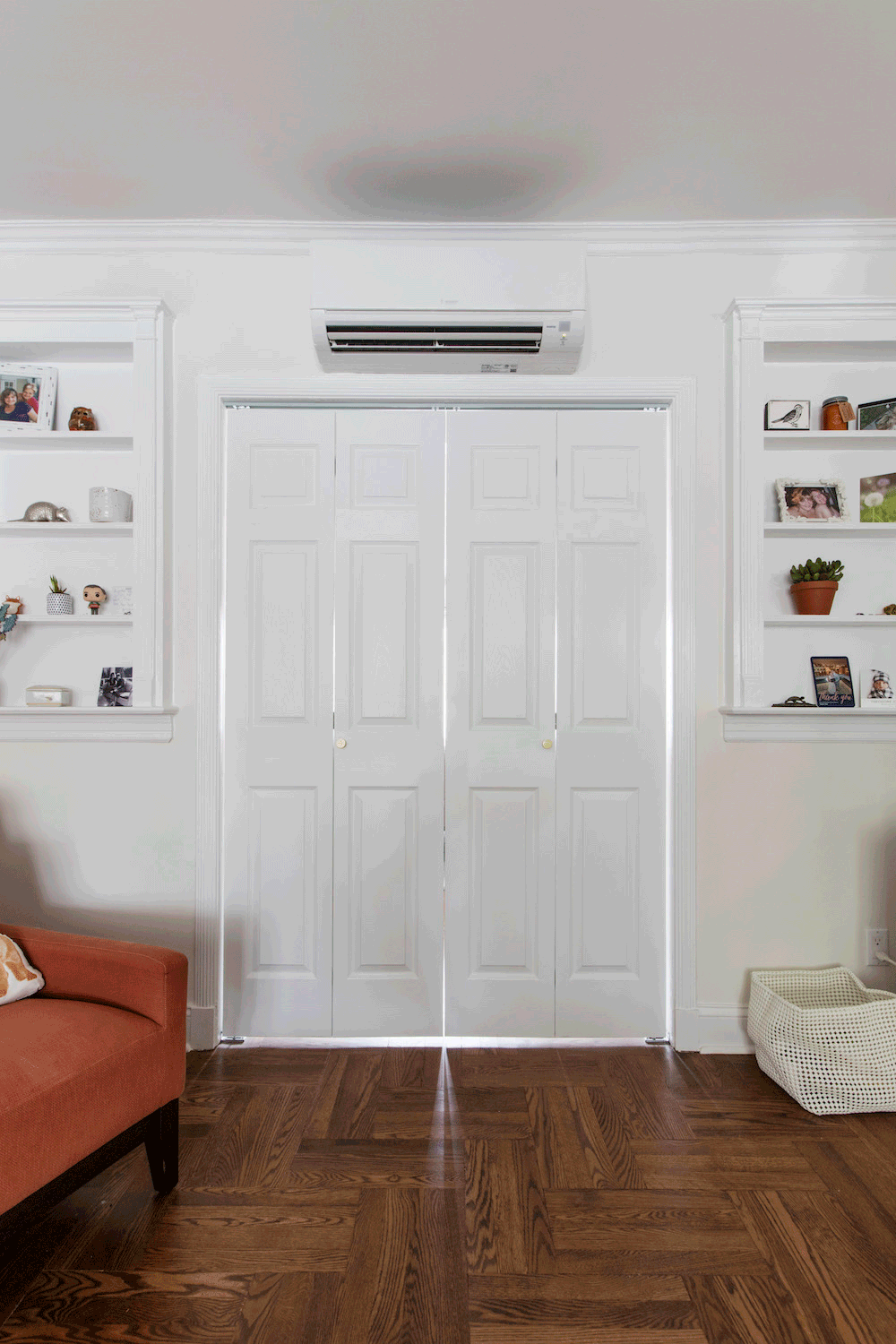 white panelled double door in a brown floored room and white open shelves after renovation