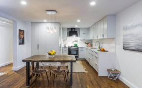white open kitchen with cabinetry and dining nook on a hardwood flooring after renovation