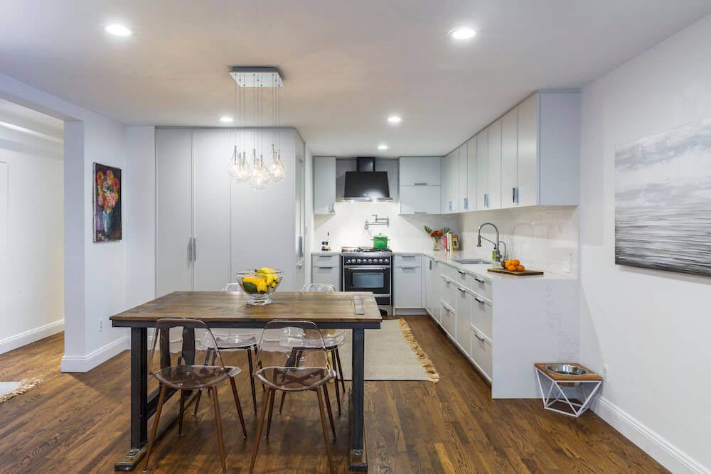 white open kitchen with cabinetry and dining nook on a hardwood flooring after renovation