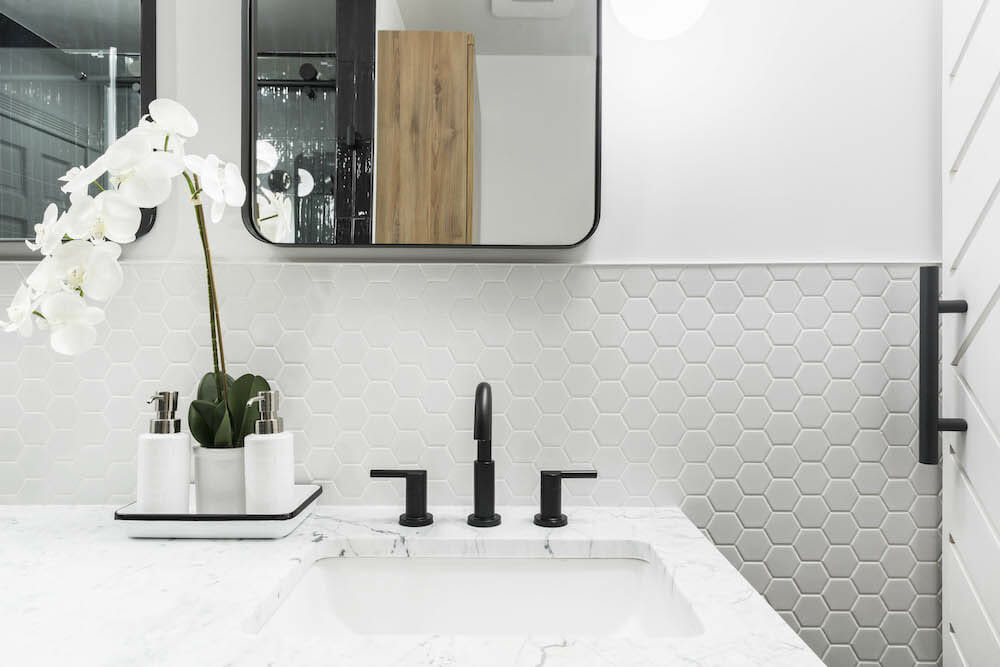 White hexogan wall tiles with vanity and sink after renovation