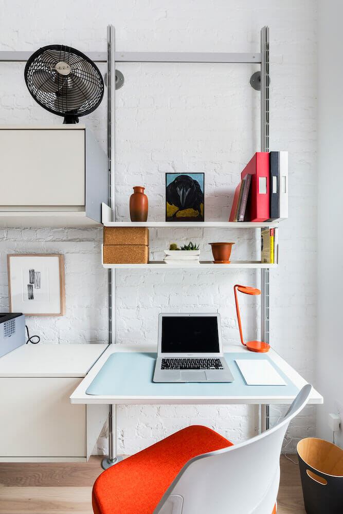 White workstation with white and red chair and open shelving unit after renovation