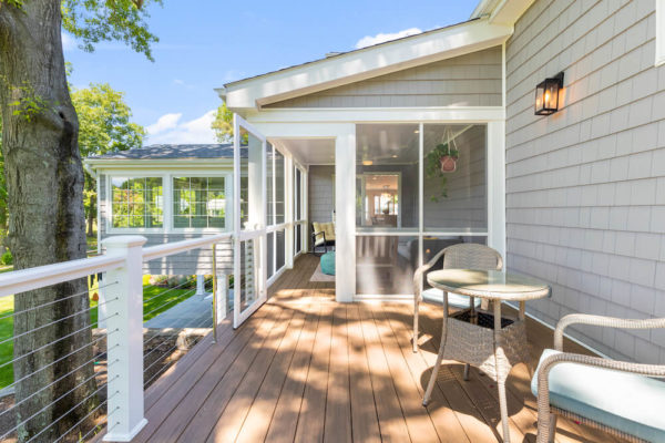 wood deck with wood framed cable rails and vinyl siding and access to sunroom after renovation