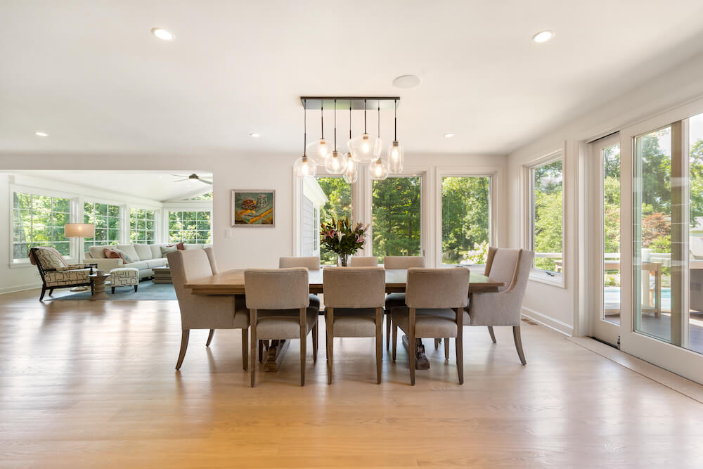 open floor plan with hardwood floors and large windows and sliding door to patio and contemporary dining lights after renovation