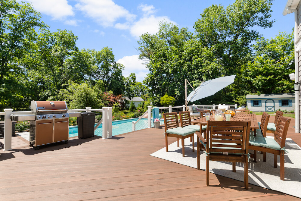 outdoor living space with swimming pool and wooden deck and patio after renovation