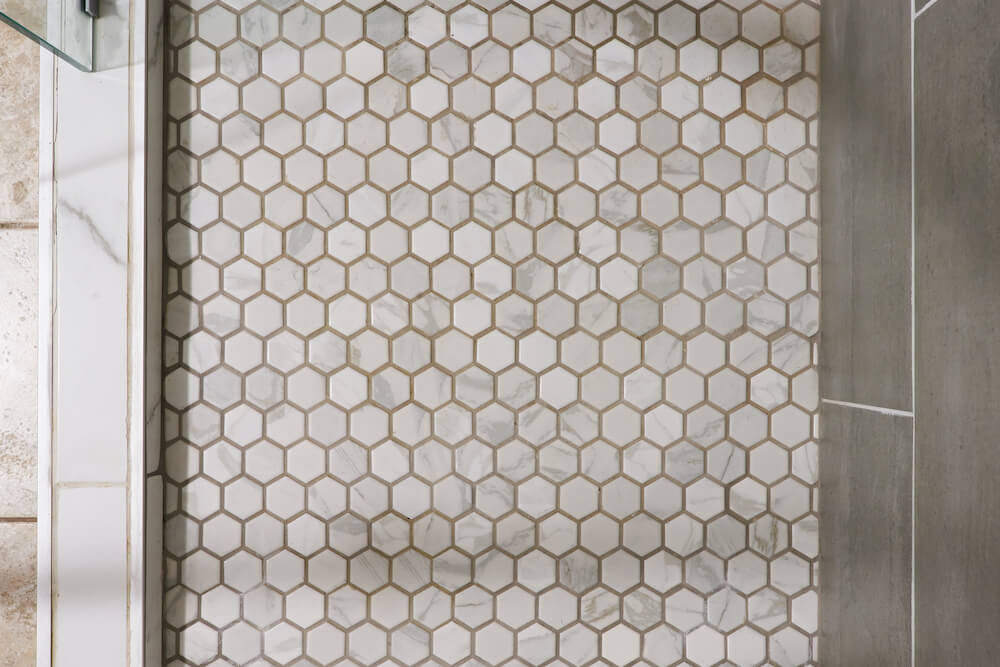 walk-in shower with honeycomb or hexagon floor tiles and glass wall after renovation