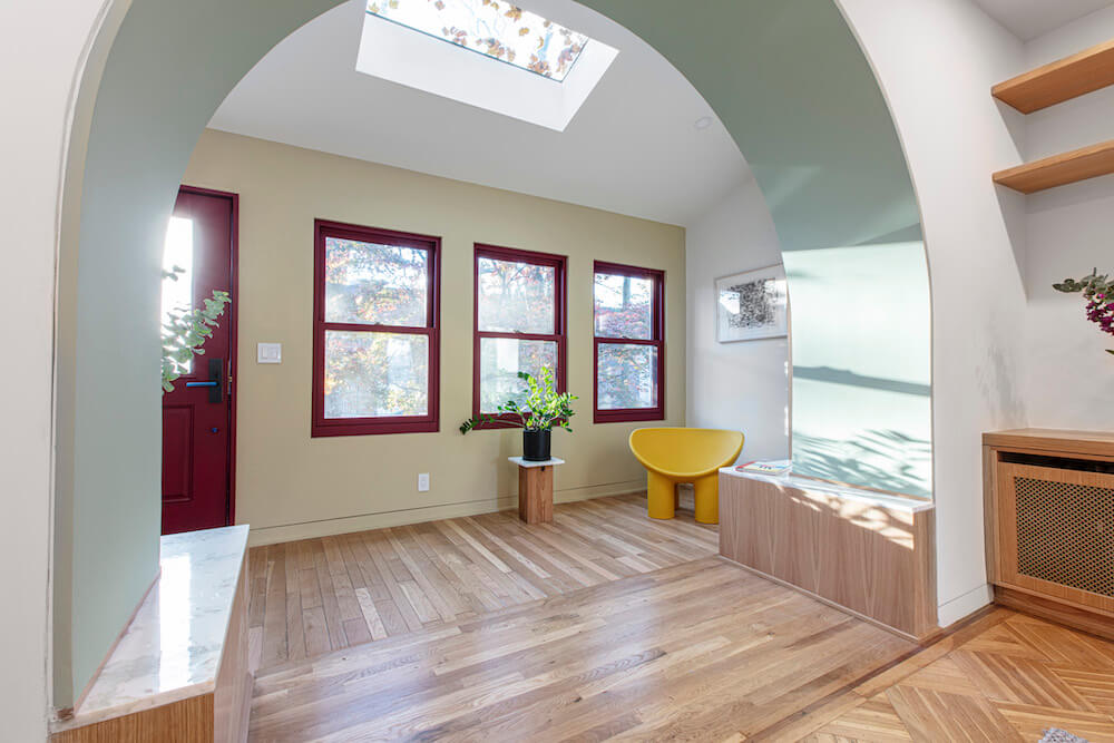 room with windows and skylight and hardwood floors and archwayafter renovation