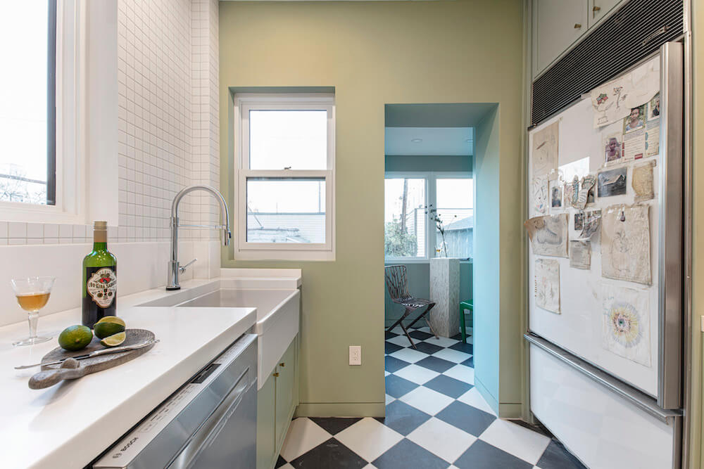 Image of a newly renovated kitchen with green walls and farmhouse sink